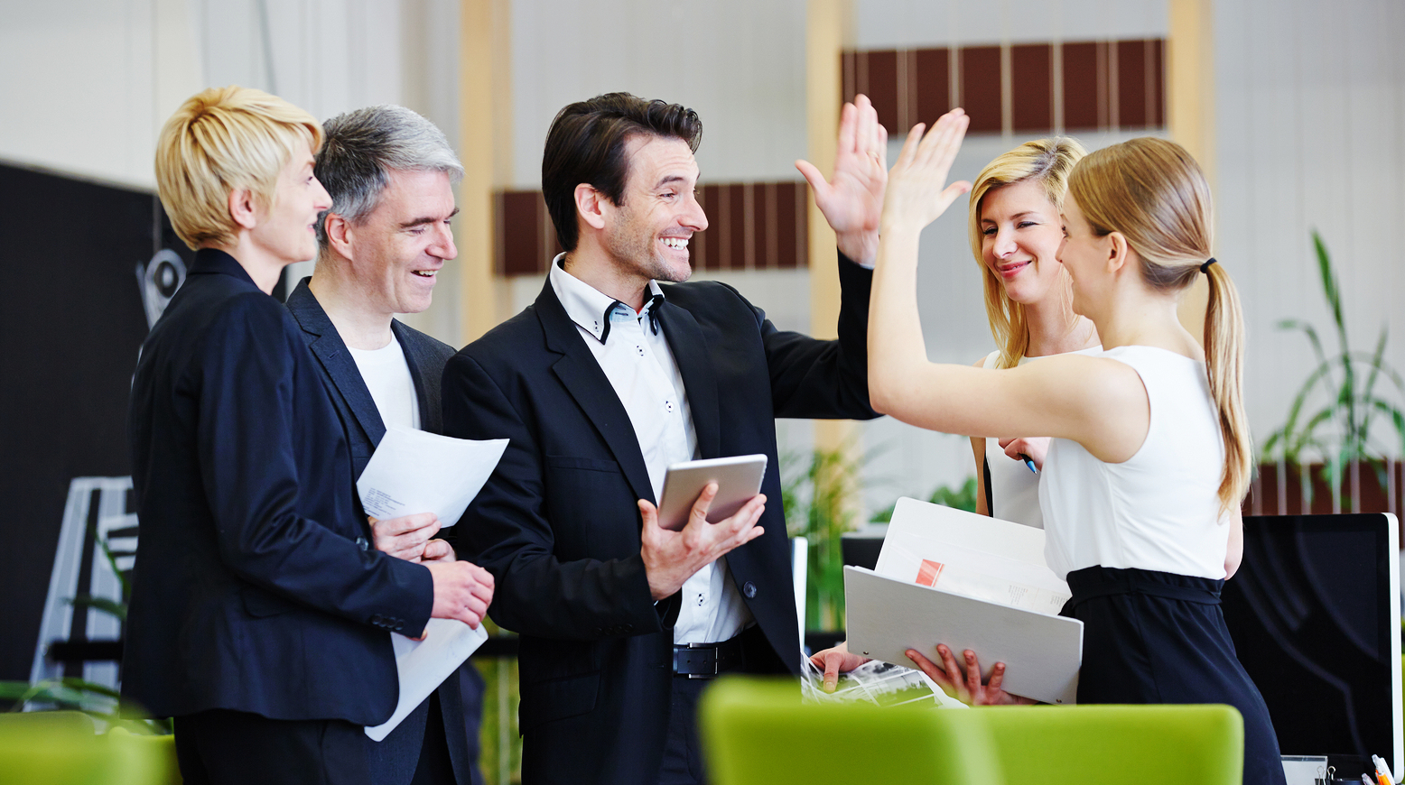 Successful team of business people giving high five in the office