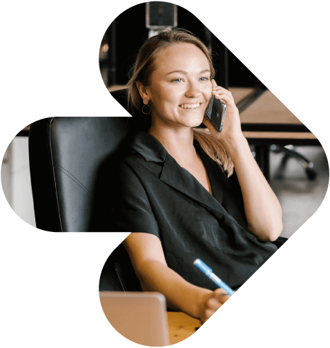 Eine Frau an einem Schreibtisch telefoniert und stellt die Rekrutierungssoftware Bullhorn für Personalagenturen vor.