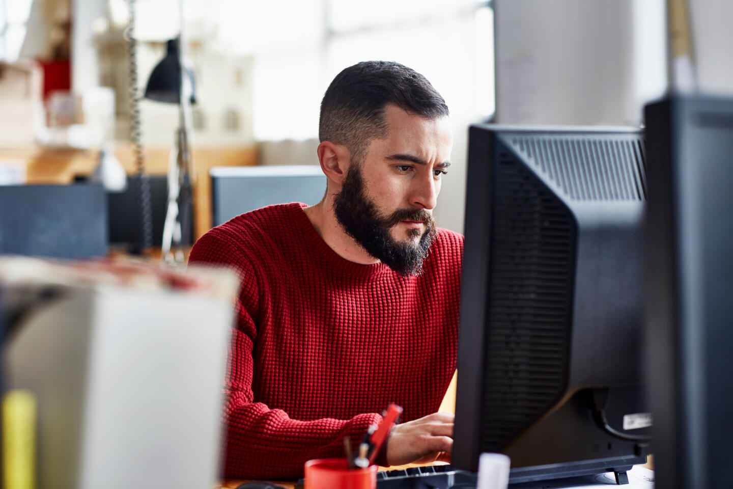 man in red sweater working on the computer