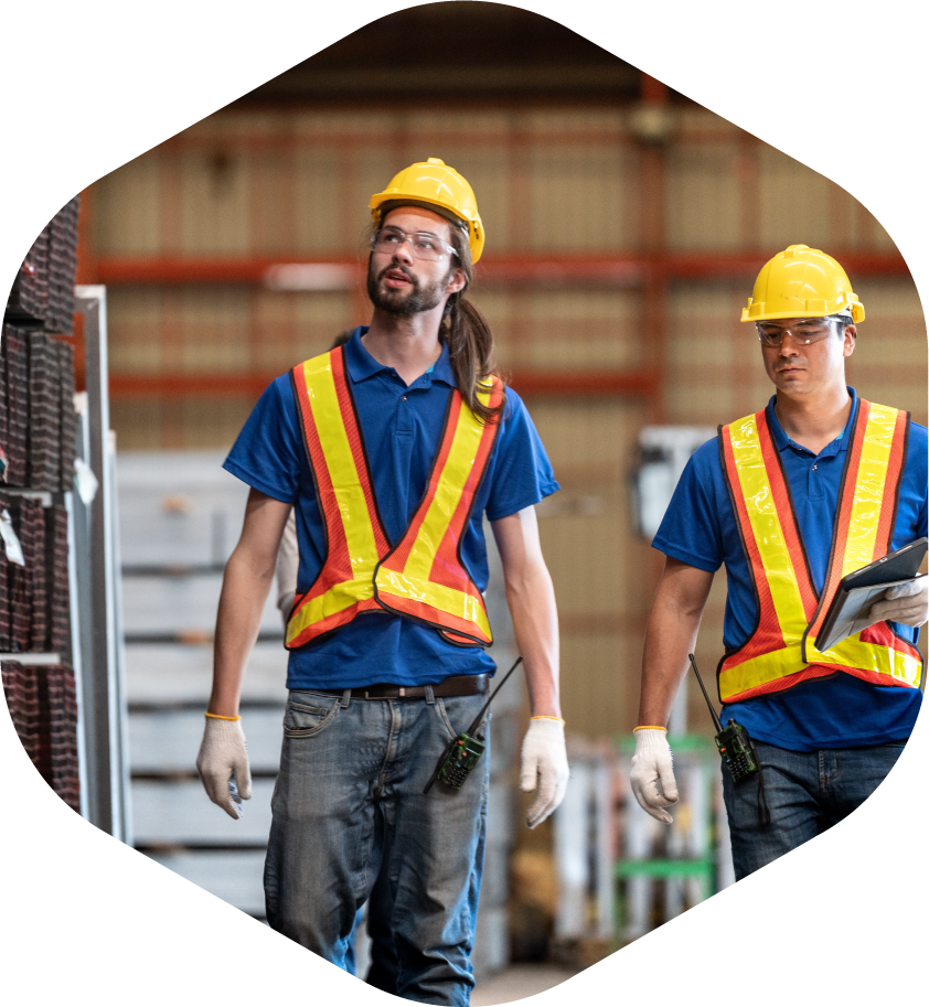 men in safety vests and hard hats in a warehouse setting